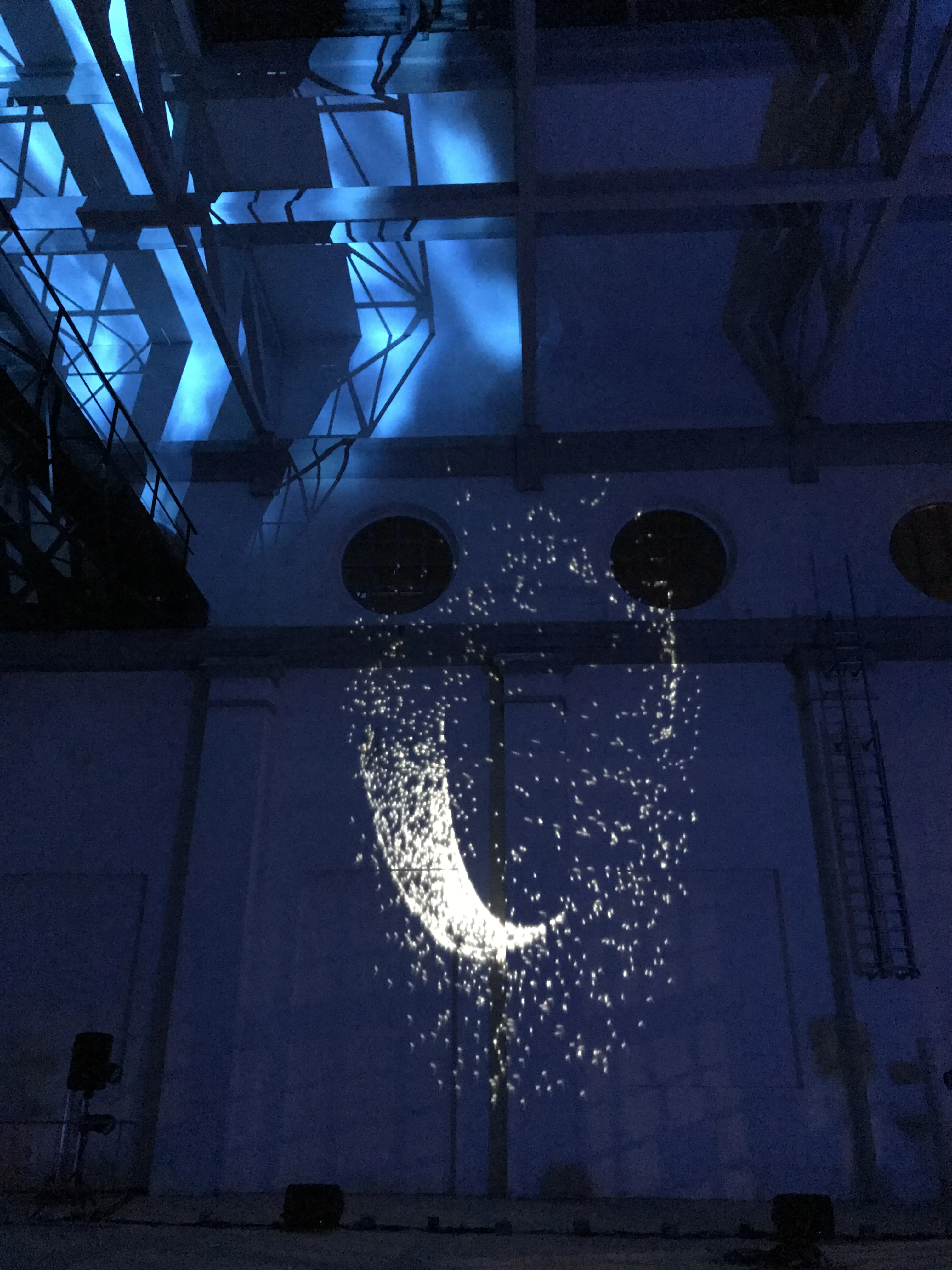 Scia di cometa proiettata sulla parete industriale della Ex Centrale ENEL — scenografia digitale generata dal suono in tempo reale, Danza Liquida SUONO E LUCE