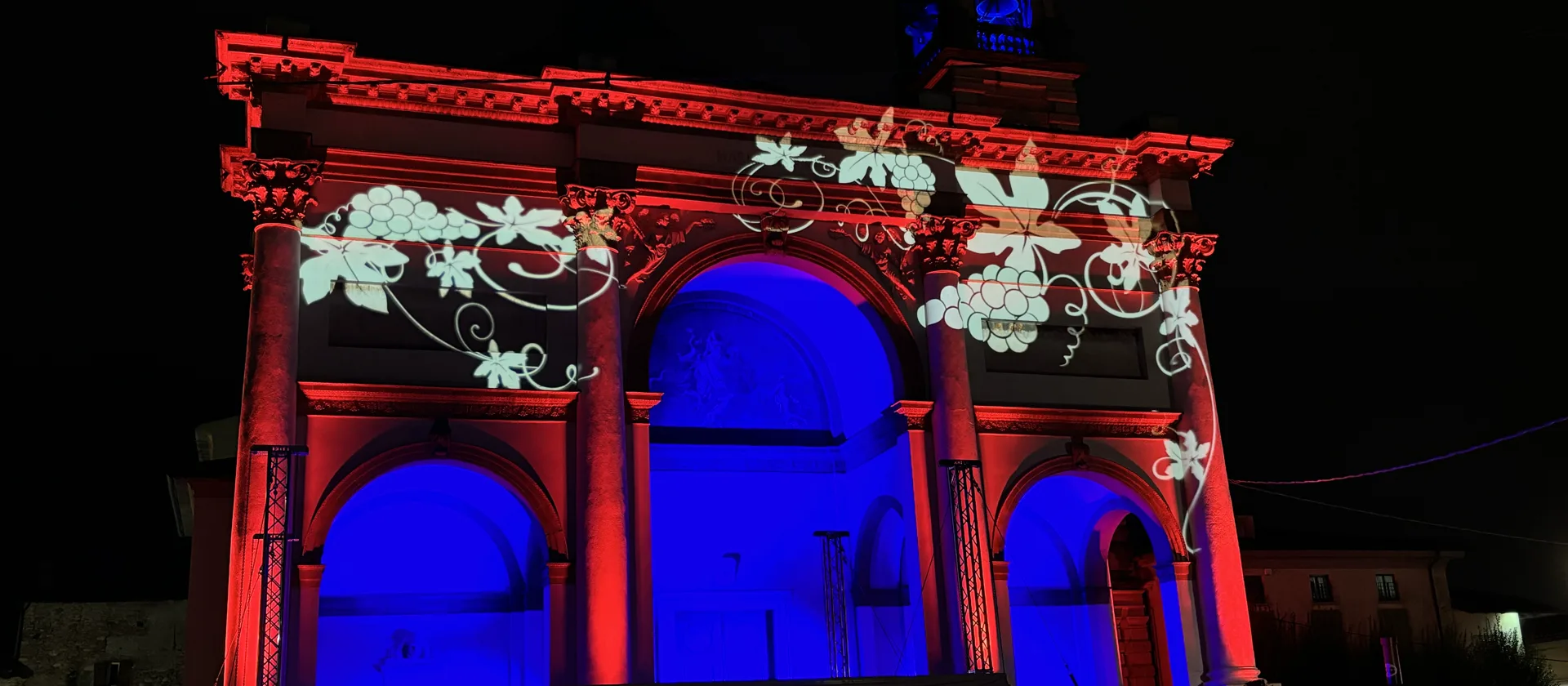 Dettaglio maxiproiezione con grappoli d'uva e tralci sulla facciata della Chiesa di Rosciate — SUONO E LUCE per la Festa del Moscato di Scanzo