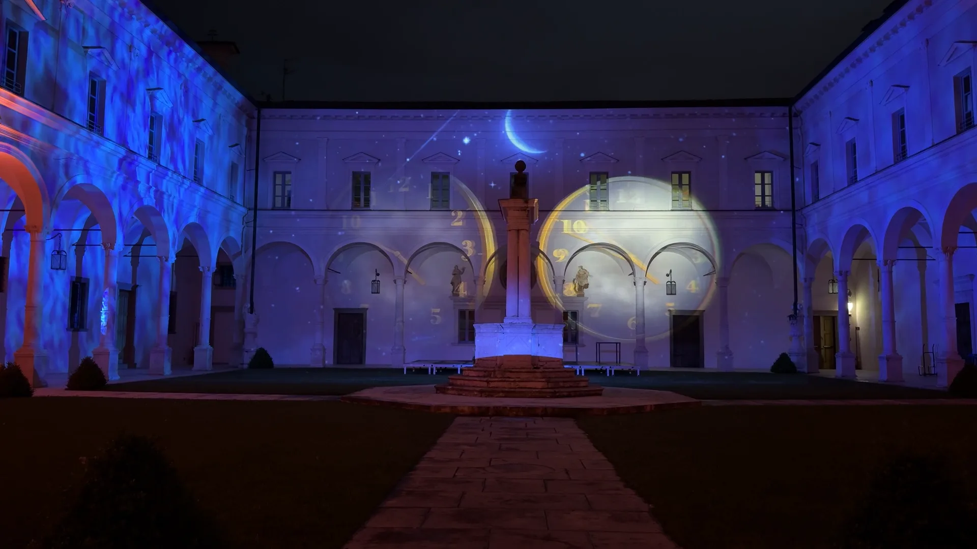 Luna e orologi proiettati sulla facciata del chiostro benedettino — il passaggio del tempo nella storia dell'Abbazia, videomapping e light design per il patrimonio culturale, SUONO E LUCE