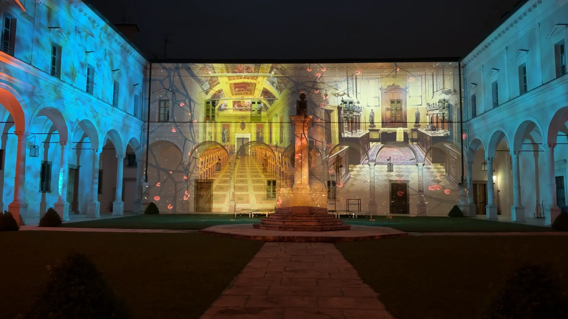 Scalinata dorata e architettura interna dell'Abbazia proiettate in blu e ciano sulla facciata del chiostro — proiezioni su facciate e illuminazione architettonica, Abbazia di San Paolo d'Argon, SUONO E LUCE